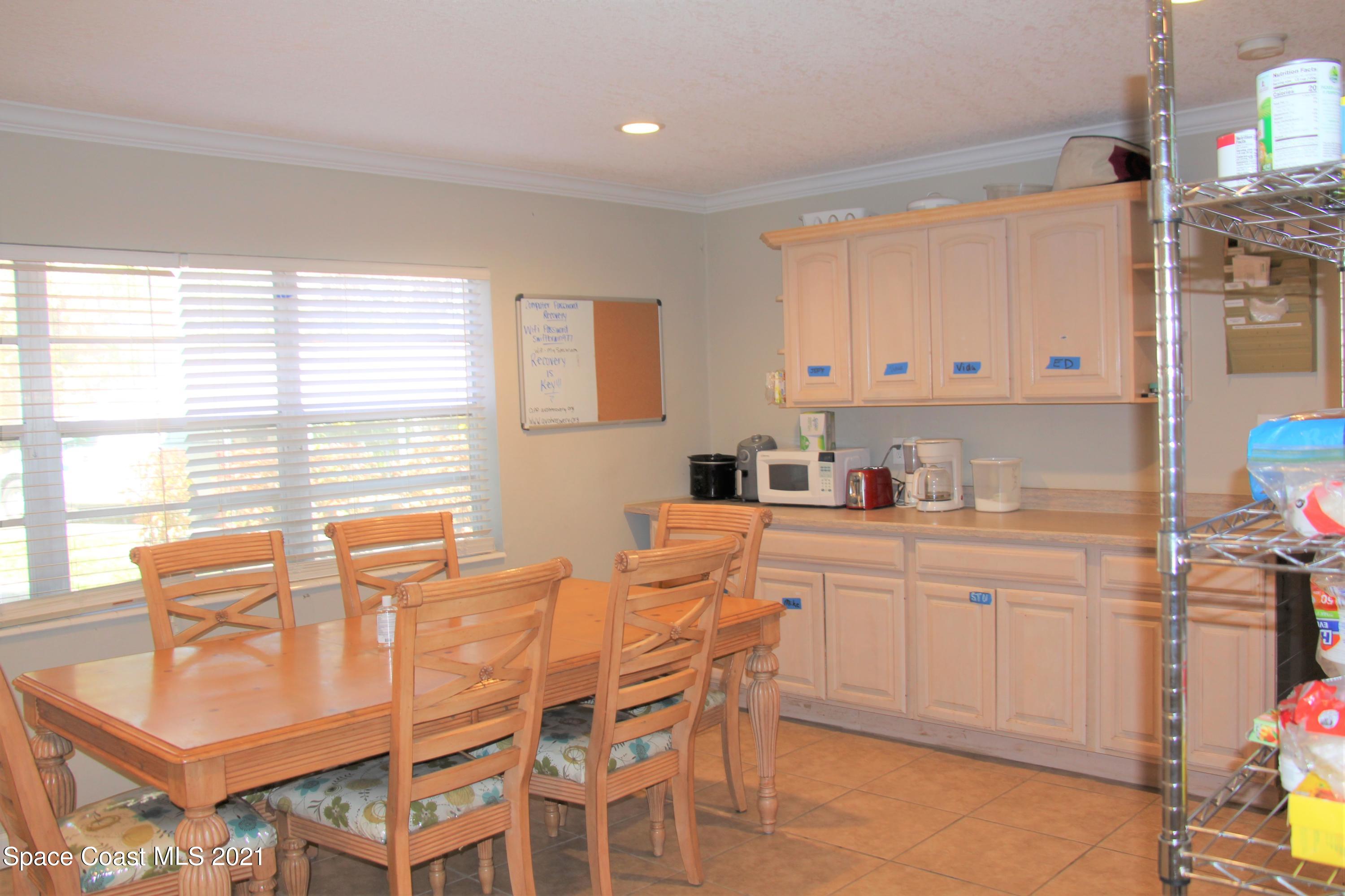 1013 South Wickham Road West Melbourne, FL 32904 - Photo 3 of 16 a kitchen with stainless steel appliances kitchen island granite countertop a table and chairs in it