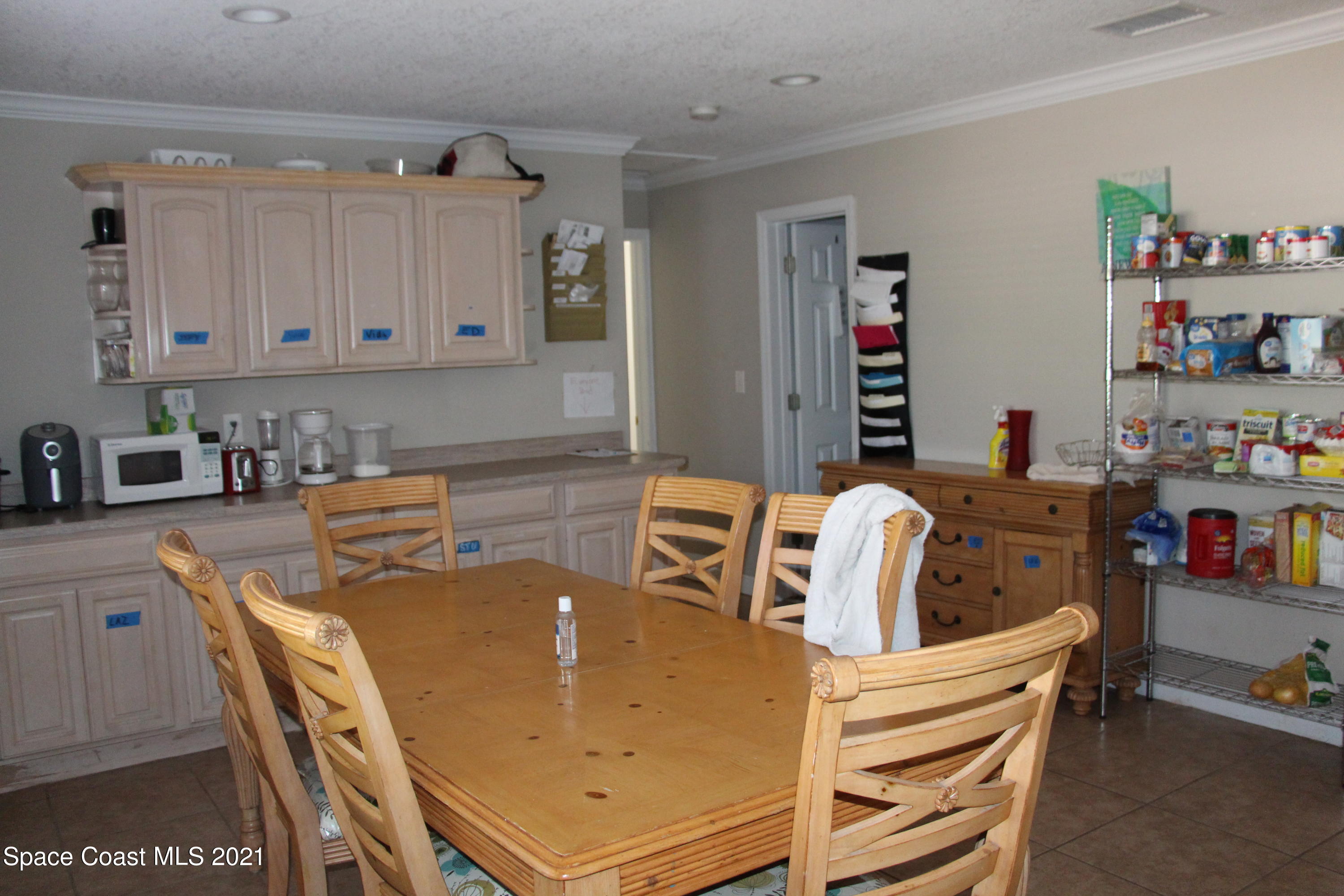 1013 South Wickham Road West Melbourne, FL 32904 - Photo 4 of 16 a kitchen with a table chairs and a refrigerator