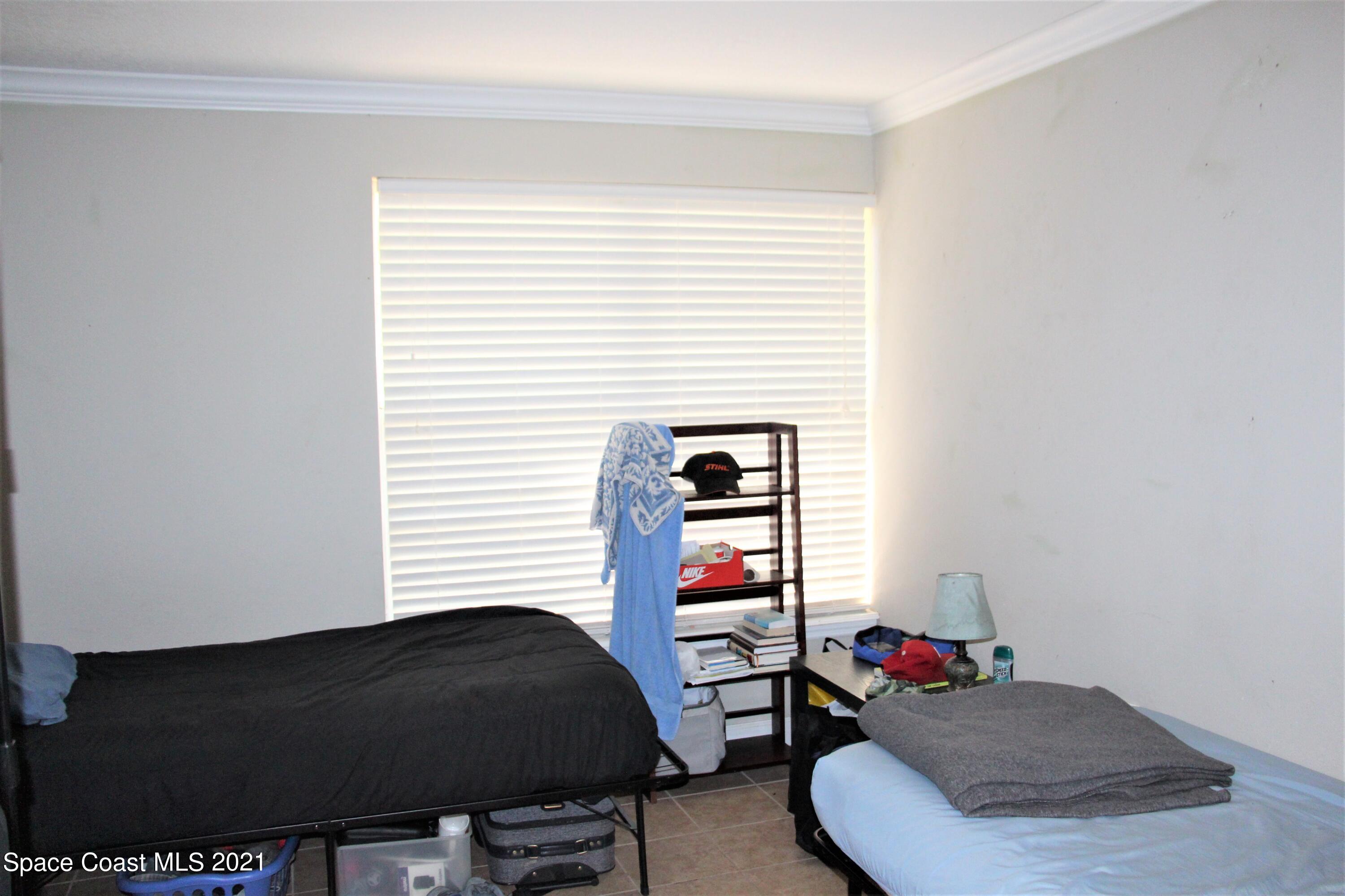 1013 South Wickham Road West Melbourne, FL 32904 - Photo 8 of 16 a bedroom with a bed and a window