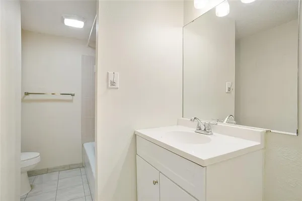a bathroom with a sink toilet and a mirror