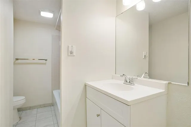 a bathroom with a sink toilet and a mirror