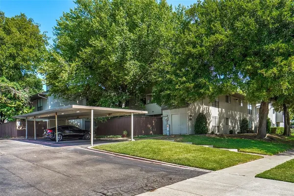 front view of a house with a yard and an trees