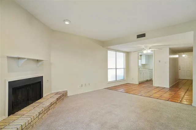 a view of empty room with windows and fireplace