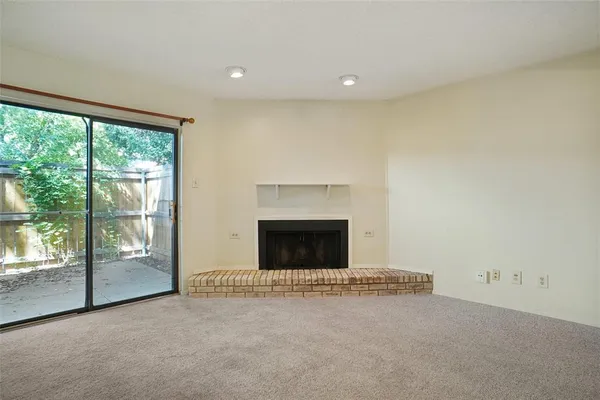 an empty room with a fireplace and a window