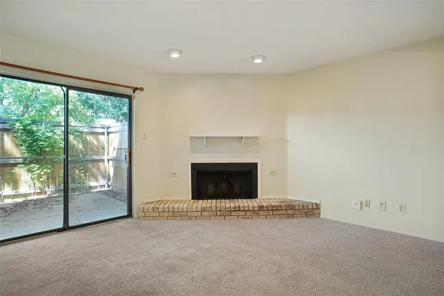 an empty room with a fireplace and a window
