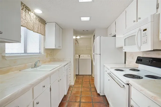 a kitchen with white cabinets and white appliances