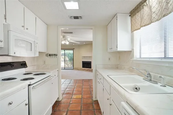 a kitchen with a sink stove top oven and cabinets