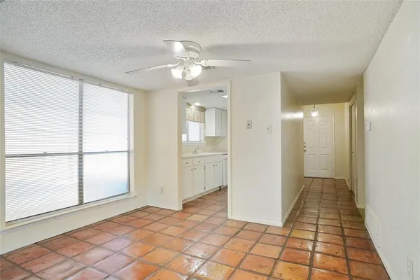 a view of a hallway with wooden floor and a bathroom