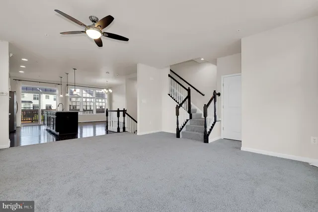 a view of an empty room with furniture and a ceiling fan