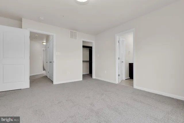 an empty room with closet and a bathroom