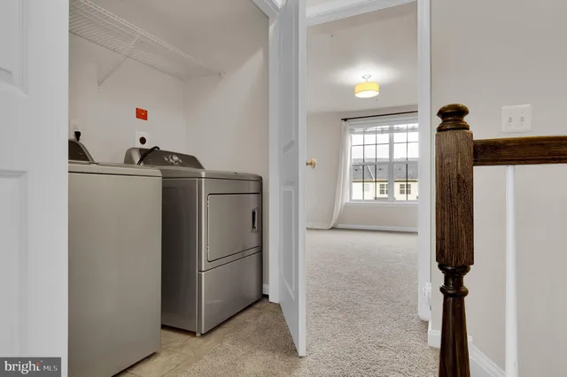 a utility room with closet dryer and windows
