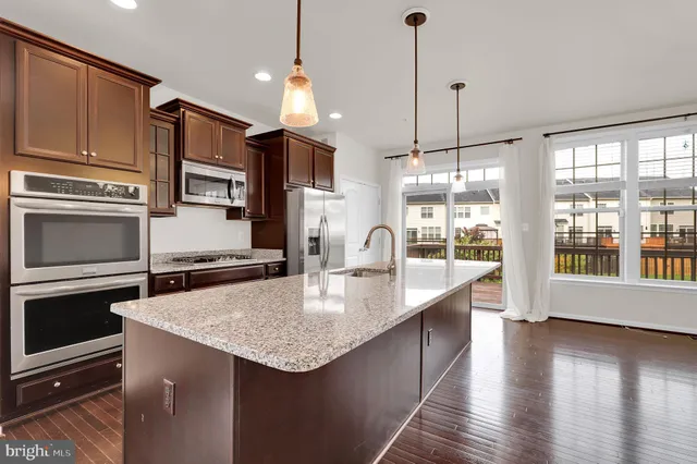 a kitchen with stainless steel appliances granite countertop a sink a oven and a stove