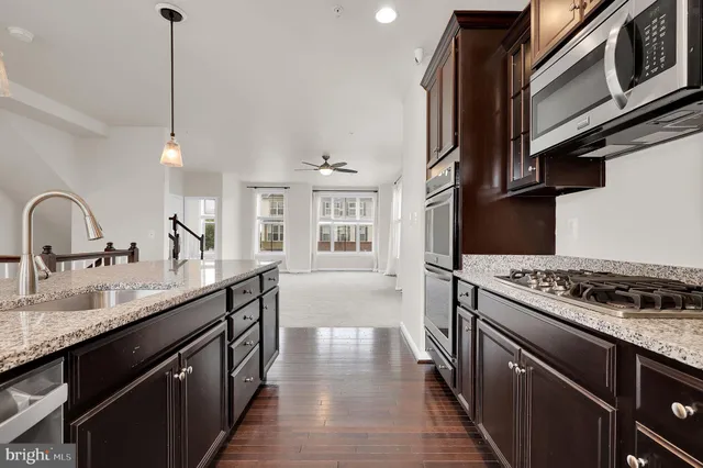 a kitchen with stainless steel appliances granite countertop a stove a sink and a microwave