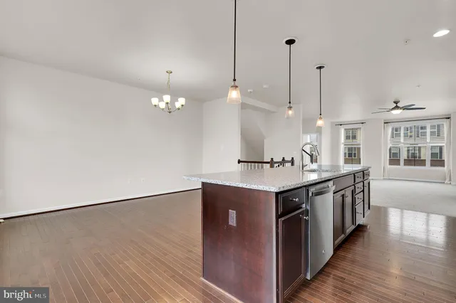 a kitchen with stainless steel appliances granite countertop a sink a stove a refrigerator and a large window