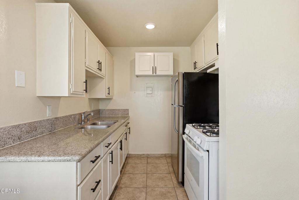 1920 North H Street, Unit 133 Oxnard, CA 93036 - Photo 6 of 14 a kitchen with a sink stove and refrigerator