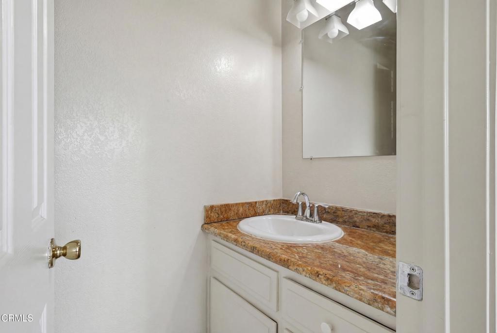 1920 North H Street, Unit 133 Oxnard, CA 93036 - Photo 8 of 14 a bathroom with a granite countertop sink and a mirror