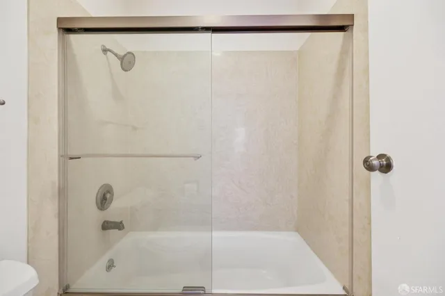 a living room with furniture a rug and a floor to ceiling window