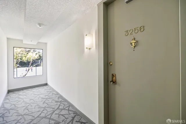 a view of an empty room with a chandelier fan