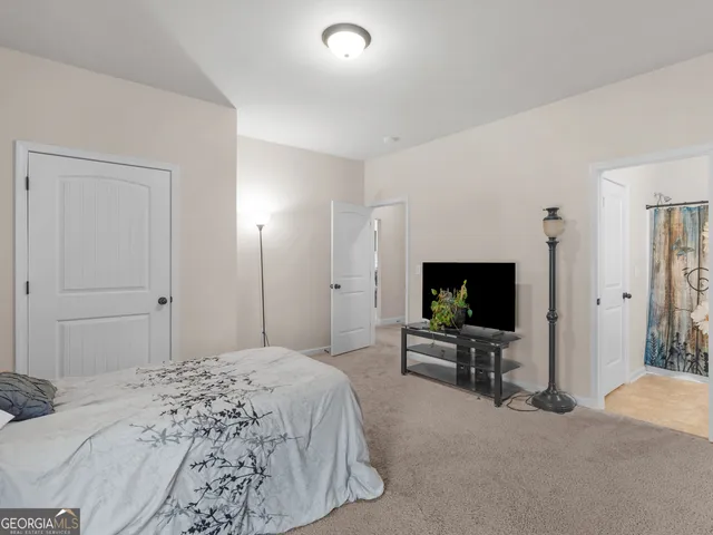a bedroom with a bed and a flat screen tv on dresser