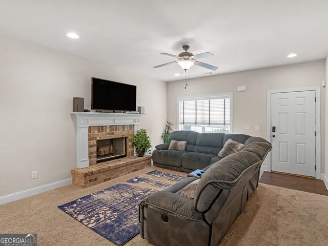 a living room with furniture a flat screen tv and a fireplace