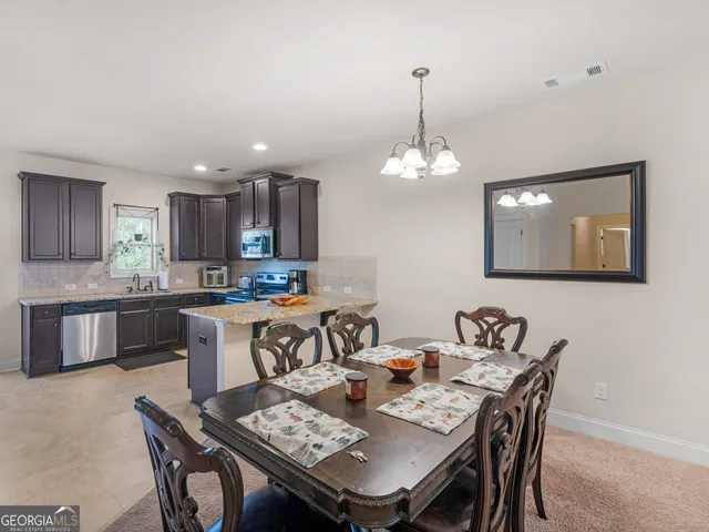 a view of a dining room and kitchen with a table chairs