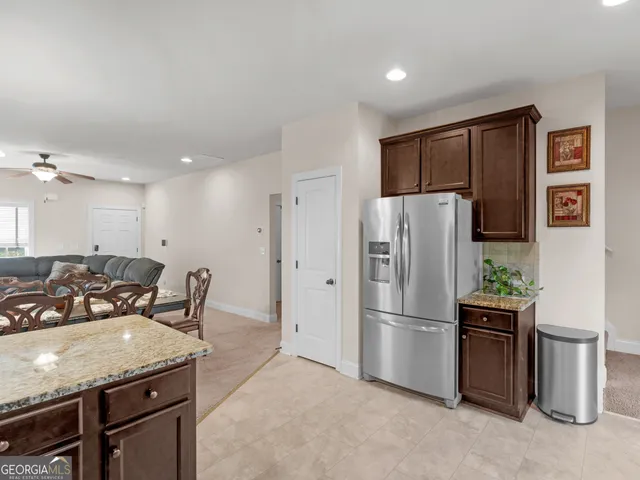 a kitchen with stainless steel appliances granite countertop a refrigerator a sink a stove and a refrigerator