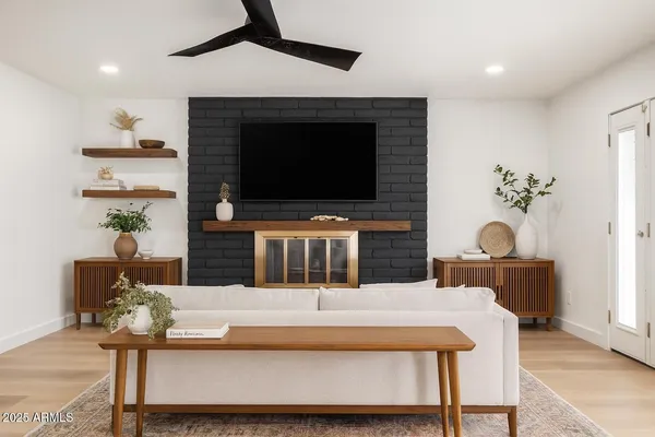 a living room with furniture a flat screen tv and a fireplace
