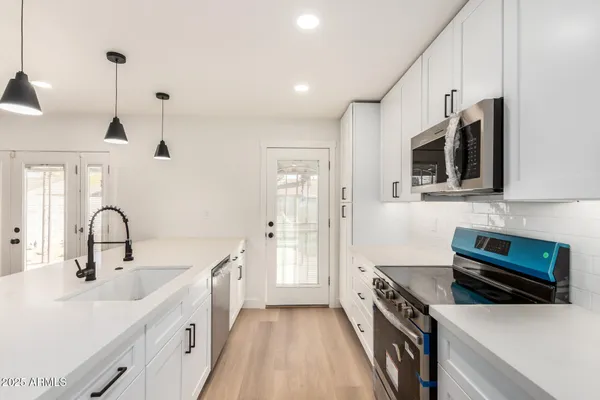 a kitchen with stainless steel appliances a stove sink and cabinets