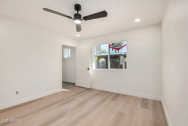 en empty room with ceiling fan and window