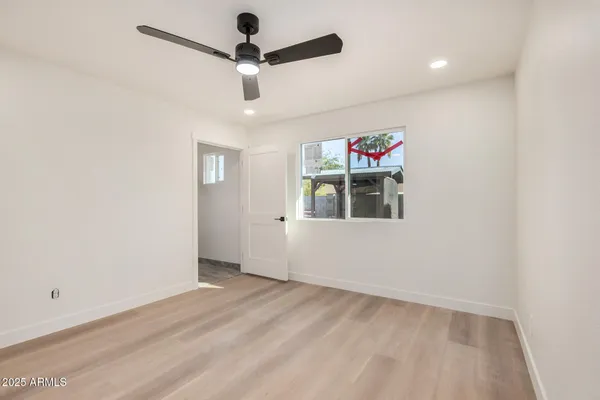 en empty room with ceiling fan and window