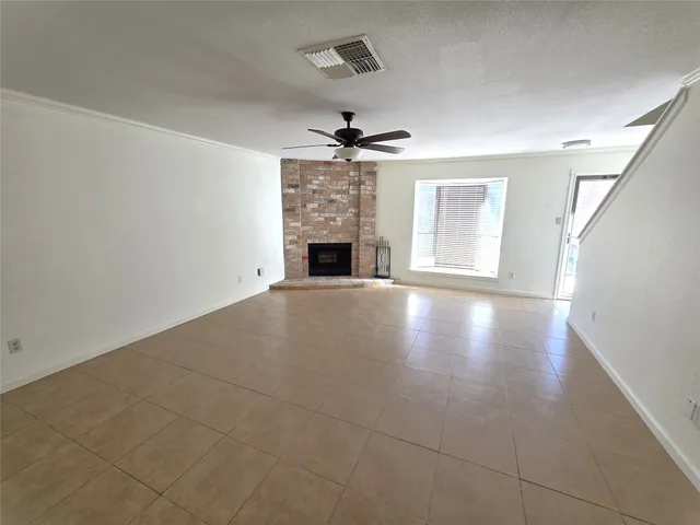 an empty room with windows and fireplace
