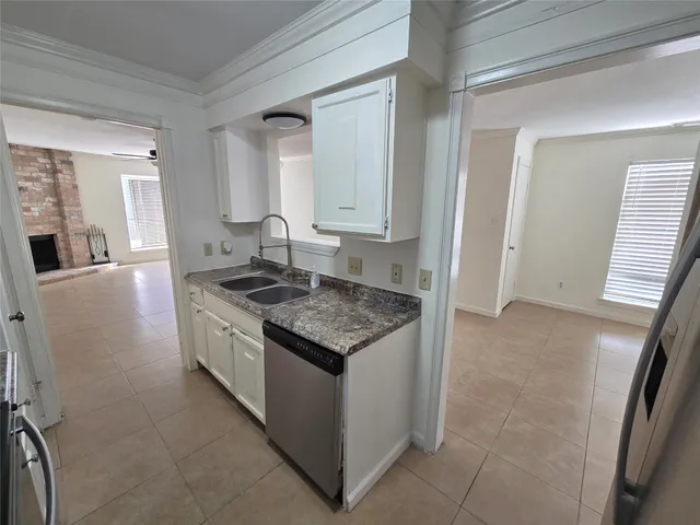 a kitchen with granite countertop a sink stove and cabinets