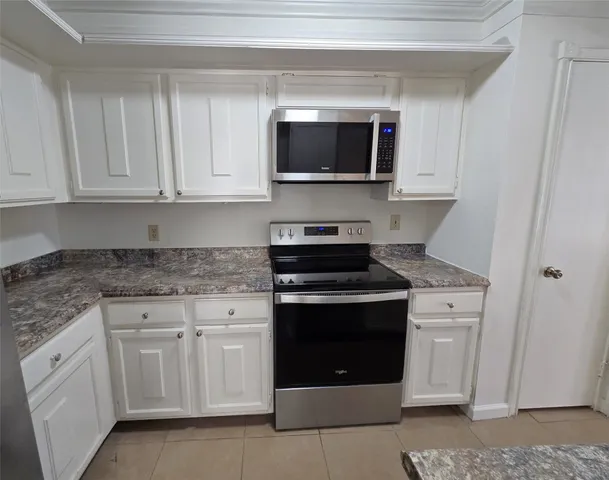 a kitchen with white cabinets and stainless steel appliances