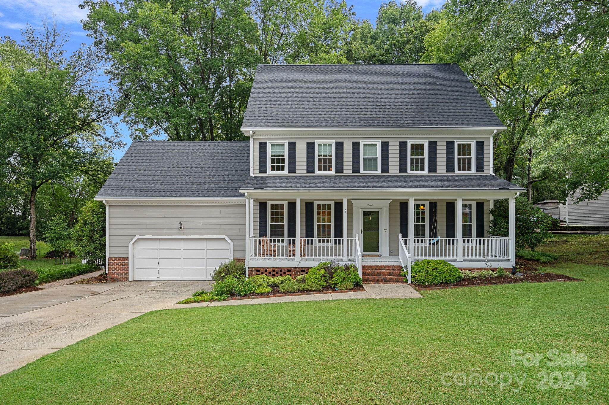 a aerial view of a house with a yard and a large tree