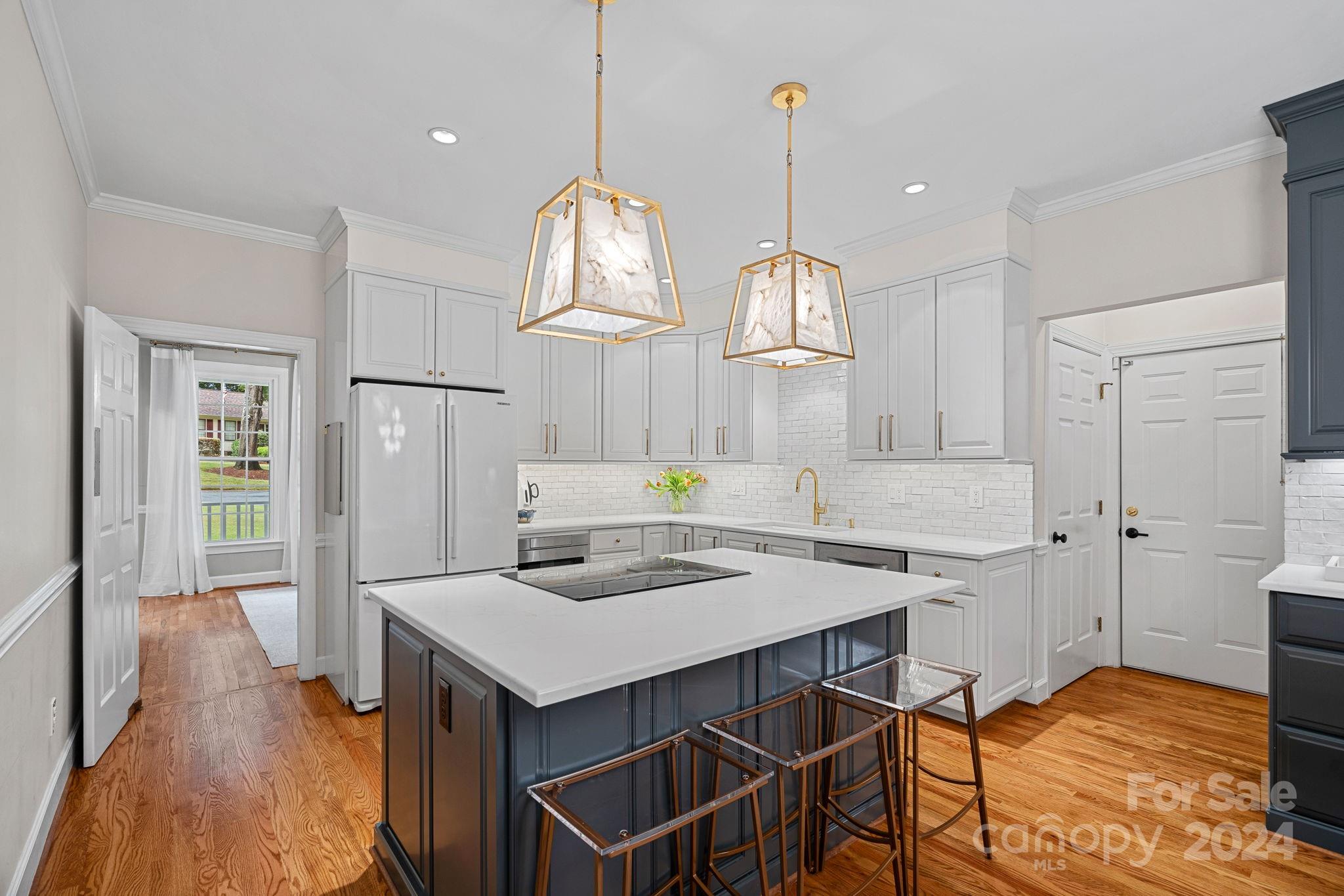 3000 Heathgate Road Charlotte, NC 28226 - Photo 5 of 48 a kitchen with kitchen island a stove a table and chairs in it