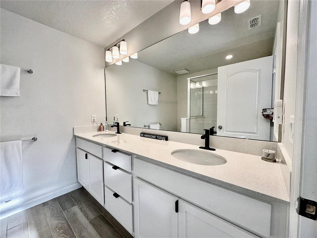 2767 North Narcoossee Road, Unit 2767 St. Cloud, FL 34771 - Photo 12 of 19 a bathroom with a sink double vanity and a mirror