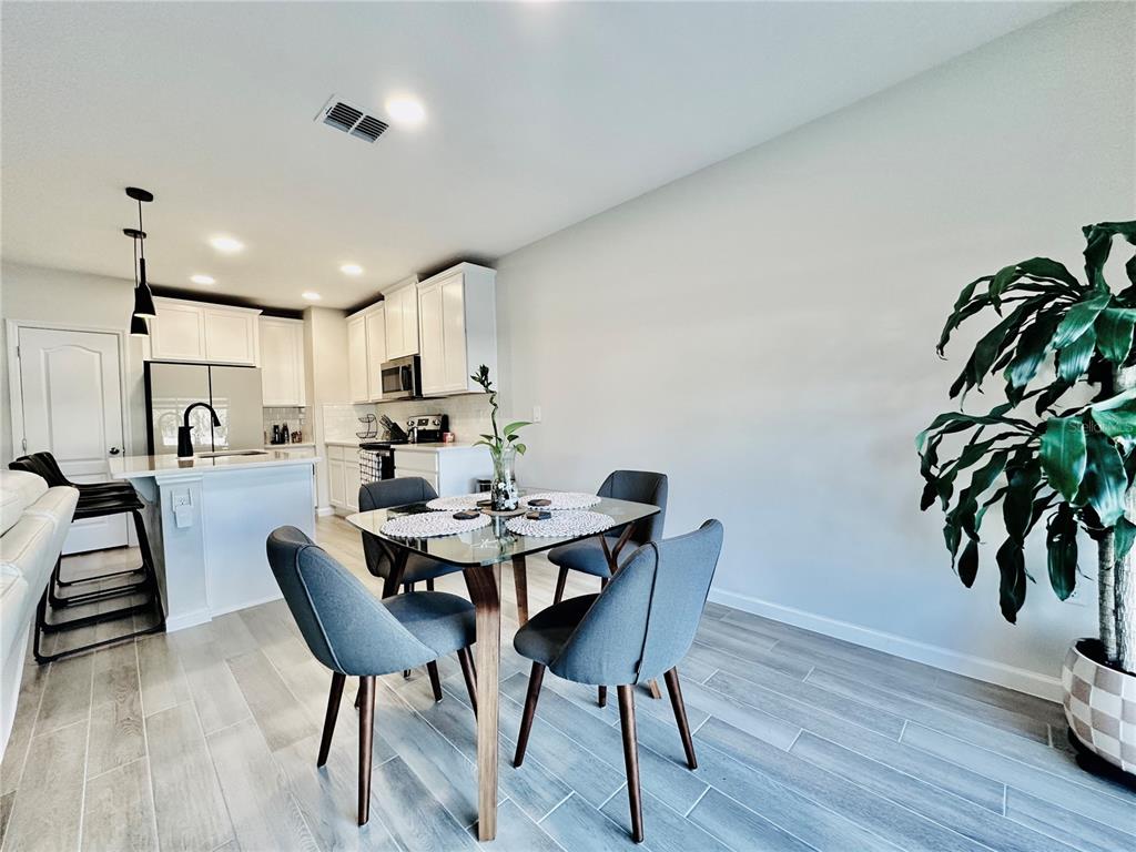 2767 North Narcoossee Road, Unit 2767 St. Cloud, FL 34771 - Photo 4 of 19 a view of a dining room with furniture and wooden floor
