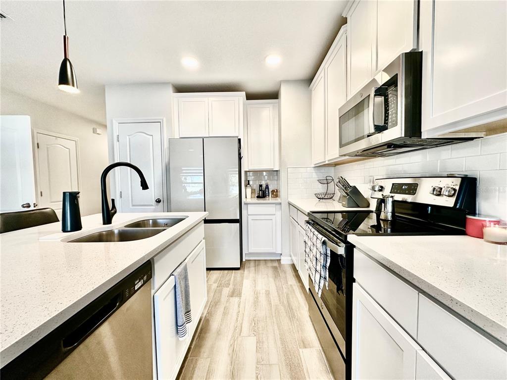 2767 North Narcoossee Road, Unit 2767 St. Cloud, FL 34771 - Photo 5 of 19 a kitchen with stainless steel appliances granite countertop a sink and a stove
