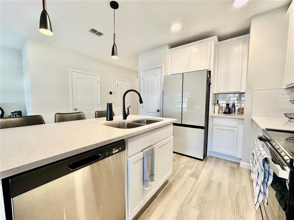 2767 North Narcoossee Road, Unit 2767 St. Cloud, FL 34771 - Photo 6 of 19 a kitchen with a sink stainless steel appliances and counter space
