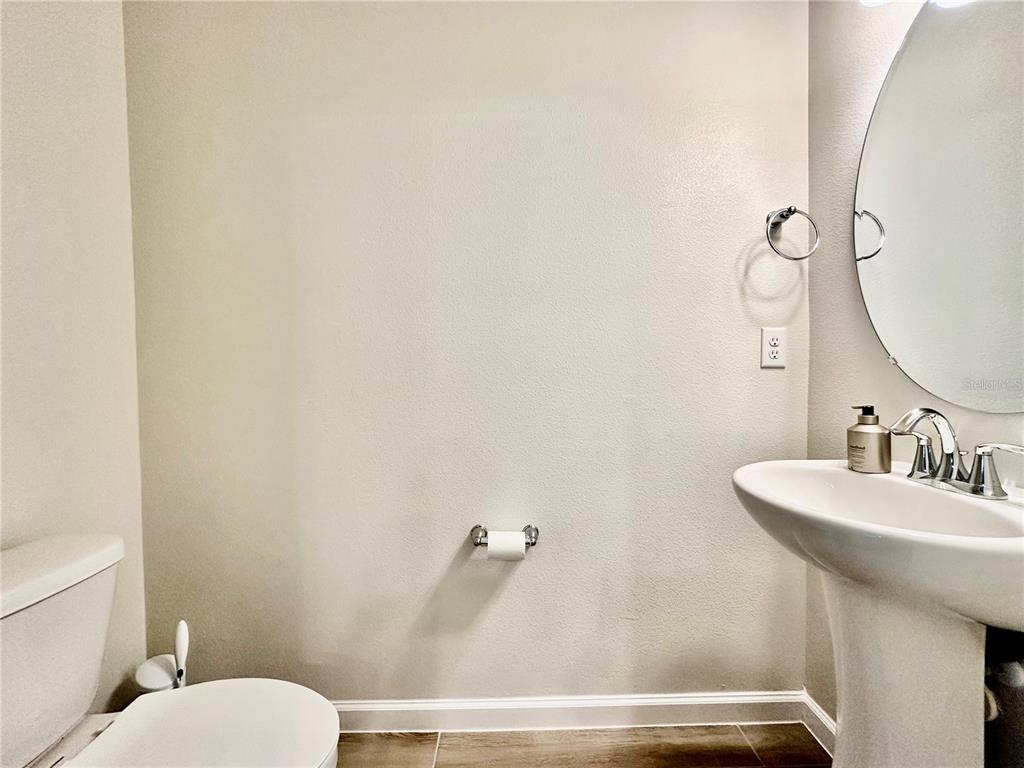 2767 North Narcoossee Road, Unit 2767 St. Cloud, FL 34771 - Photo 7 of 19 a bathroom with a sink a toilet and mirror