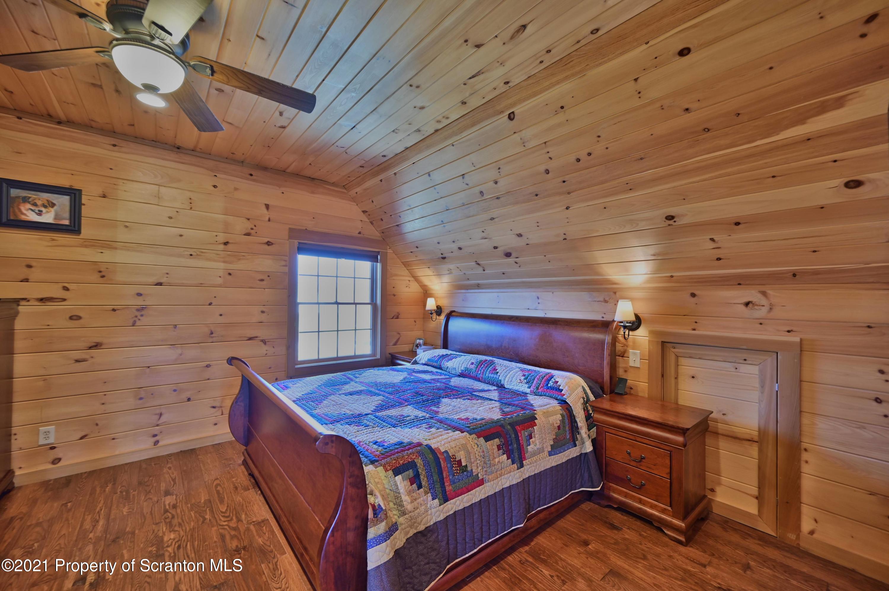 400 Summit Woods Road Moscow, PA 18444 - Photo 46 of 72 a bedroom with a bed and wooden floor