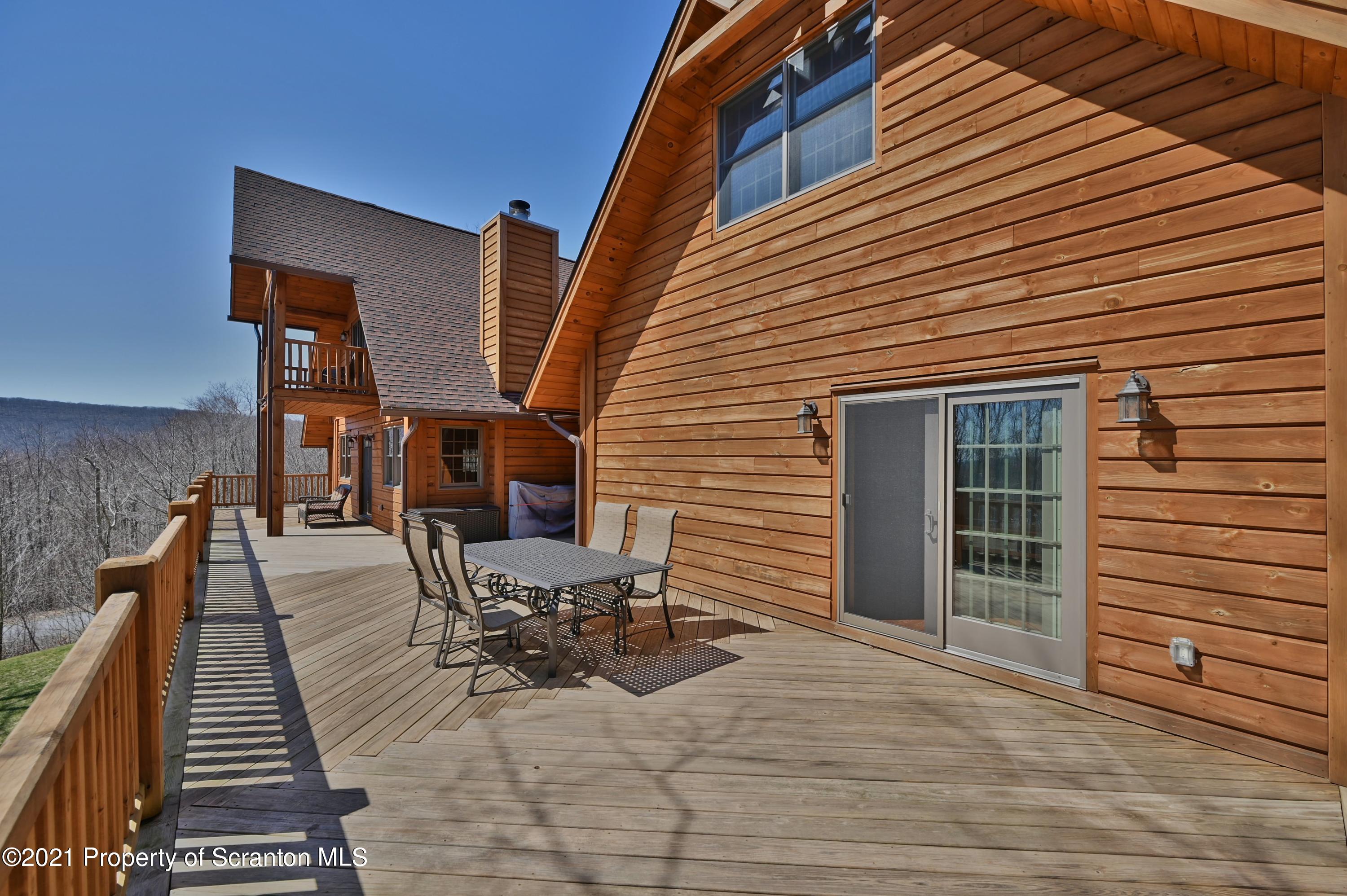 400 Summit Woods Road Moscow, PA 18444 - Photo 70 of 72 a view of a patio with table and chairs with wooden floor and fence