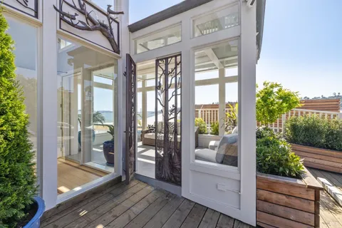 a view of a balcony with wooden floor and glass door