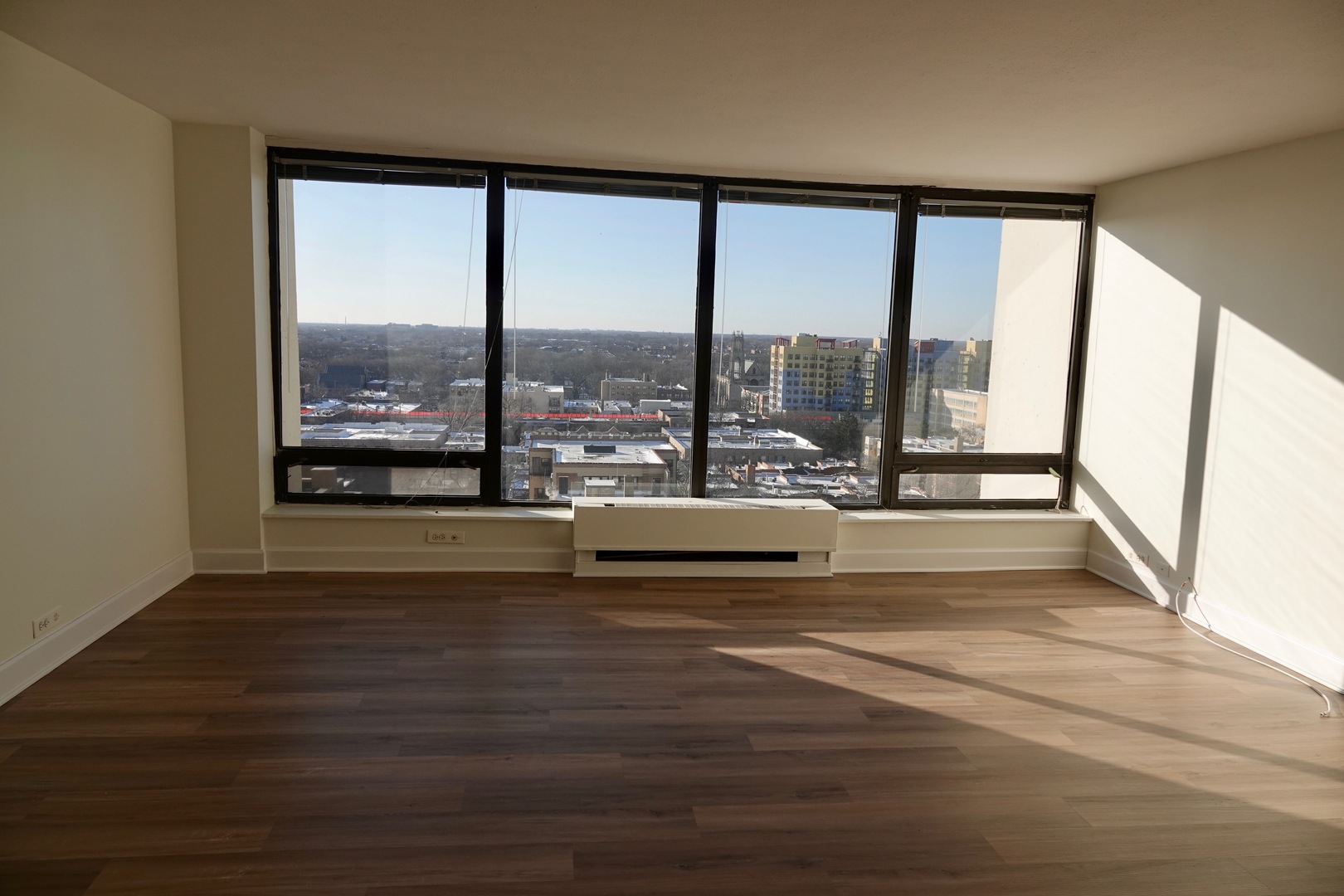 5445 North Sheridan Road, Unit 1603 Chicago, IL 60640 - Photo 17 of 40 a view of empty room with wooden floor and city view