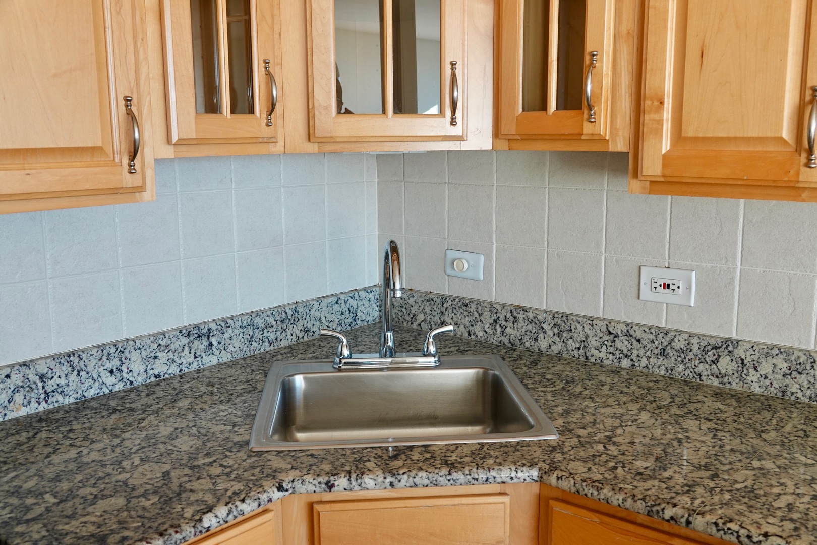 5445 North Sheridan Road, Unit 1603 Chicago, IL 60640 - Photo 32 of 40 a kitchen with granite countertop a sink and a white cabinets