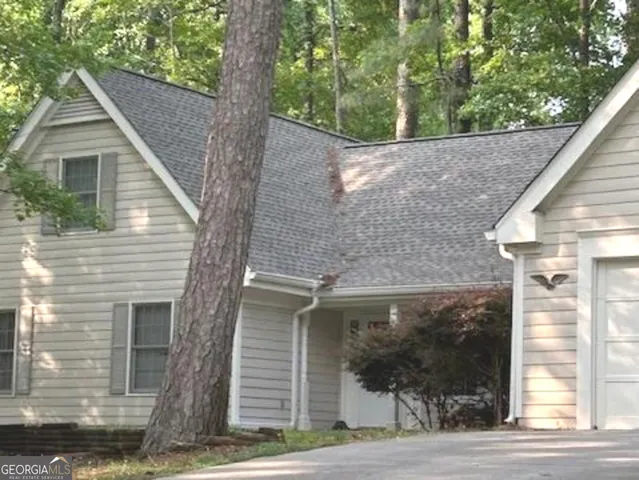 a view of a yard in front of a house with large windows