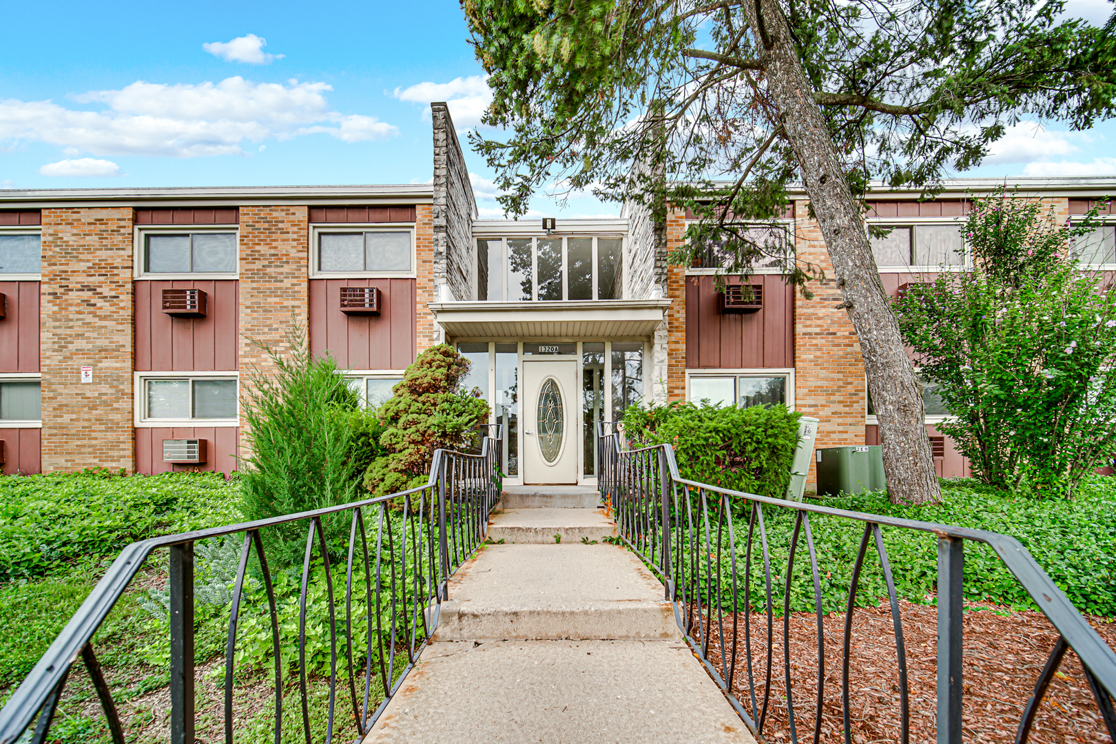 1320 Lore Lane, Unit 107B Lombard, IL 60148 - Photo 1 of 48 a front view of a house with a garden