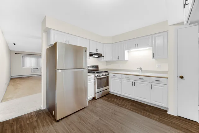 a kitchen with a refrigerator stove and wooden cabinets