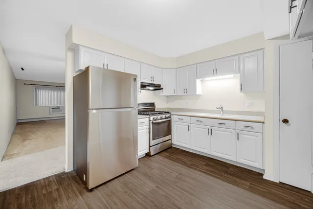 a kitchen with a refrigerator stove and wooden cabinets