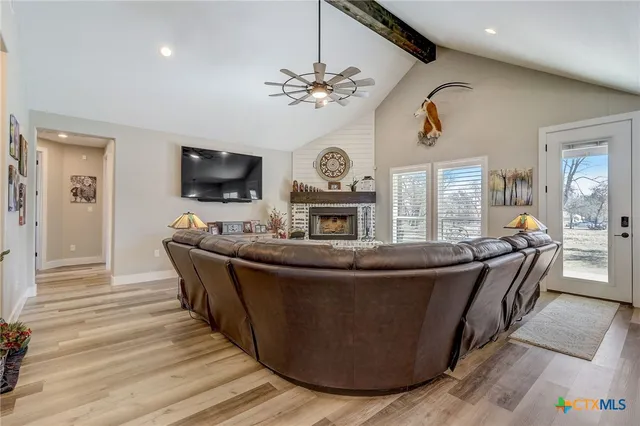 a dining room with wooden floor a chandelier a wooden table and chairs